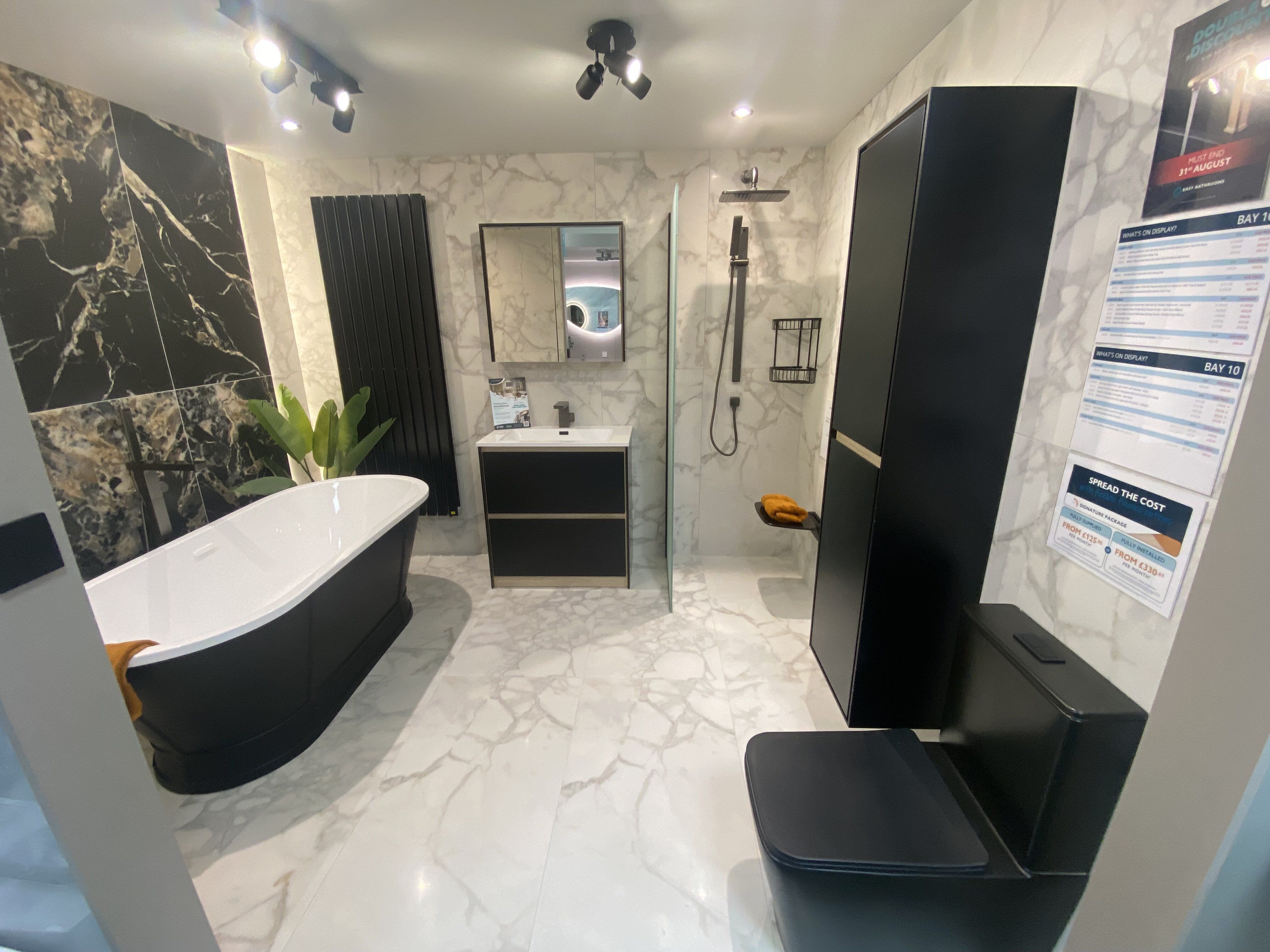 New bathroom display at Easy Bathrooms Newbury with freestanding bath, dark feature wall and contemporary finishes.