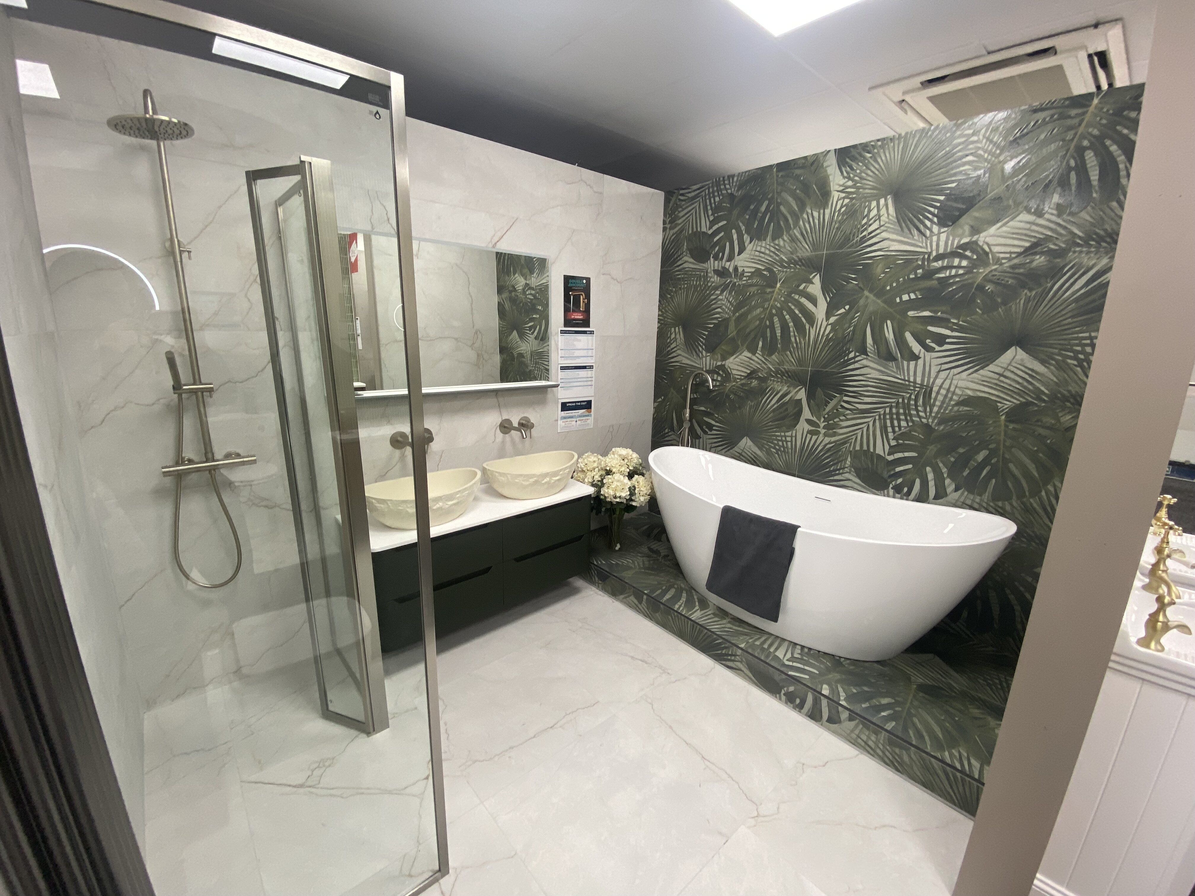 Refurbished Newbury bathroom display featuring a walk-in shower, freestanding bath and statement wall tiles.