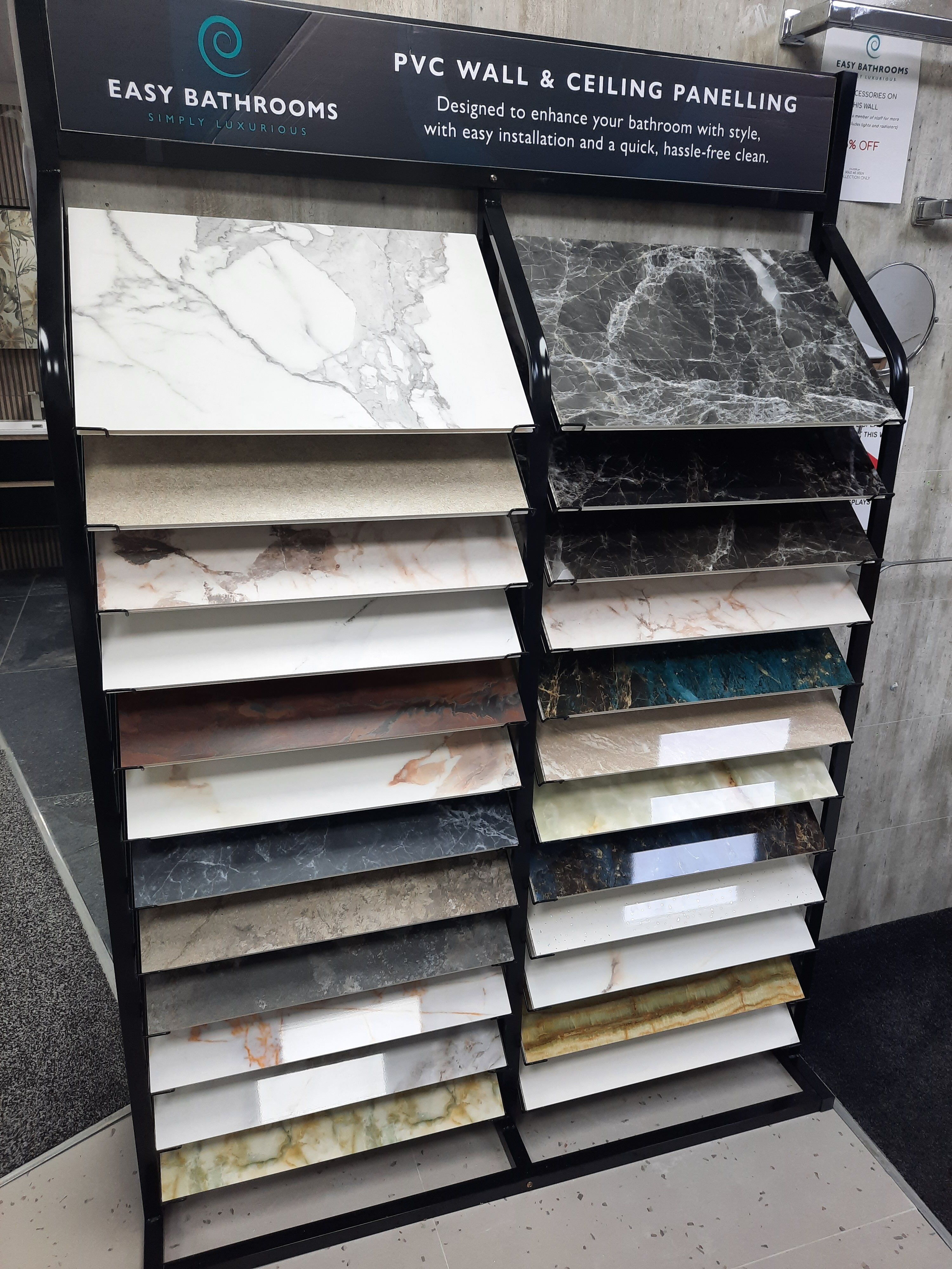 Pristina PVC wall panel sample display at Easy Bathrooms Derby showing a range of marble, stone and neutral finishes.