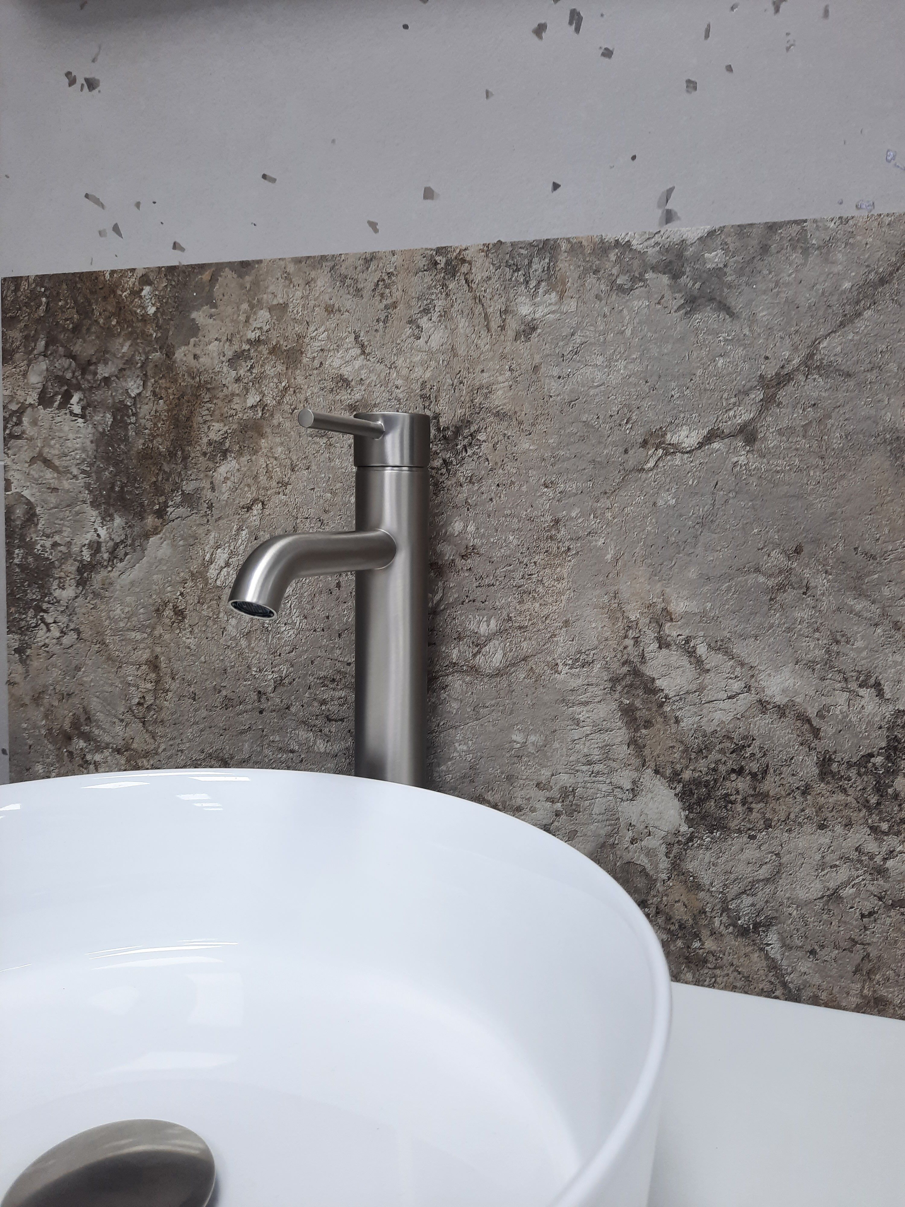Grey stone-effect Pristina PVC wall panel shown with a white basin and brushed metal tap.