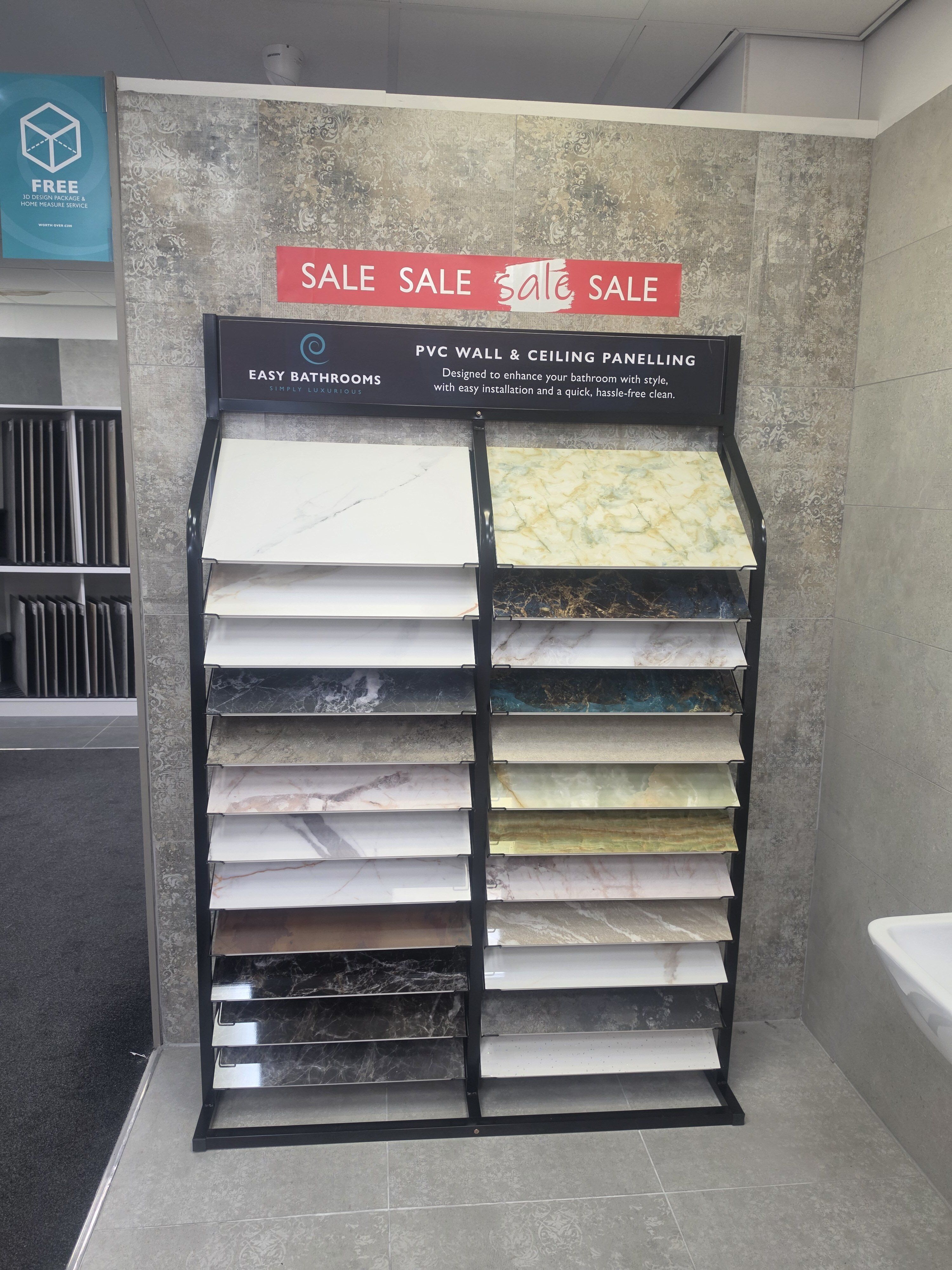 PVC shower panel sample display at Easy Bathrooms Farnborough showing a range of stone, marble and neutral-effect finishes.