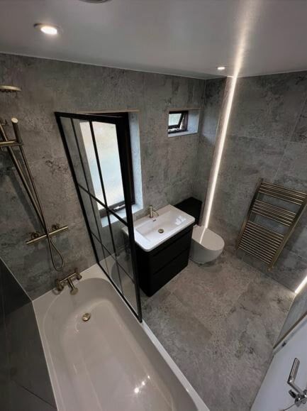 Grey concrete effect tiles paired with shower bath combination and modern shower screen