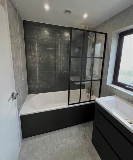 Black bathroom furniture with grey concrete effect tiles