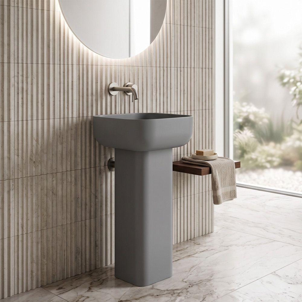matt grey full pedestal square basin with rounded corners in a neutral modern bathroom with ribbed tiled walls