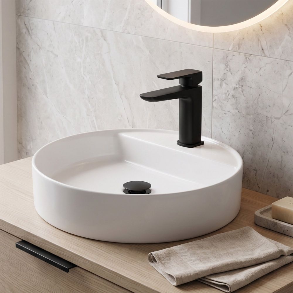 black sleek square tap and waste on top of round basin