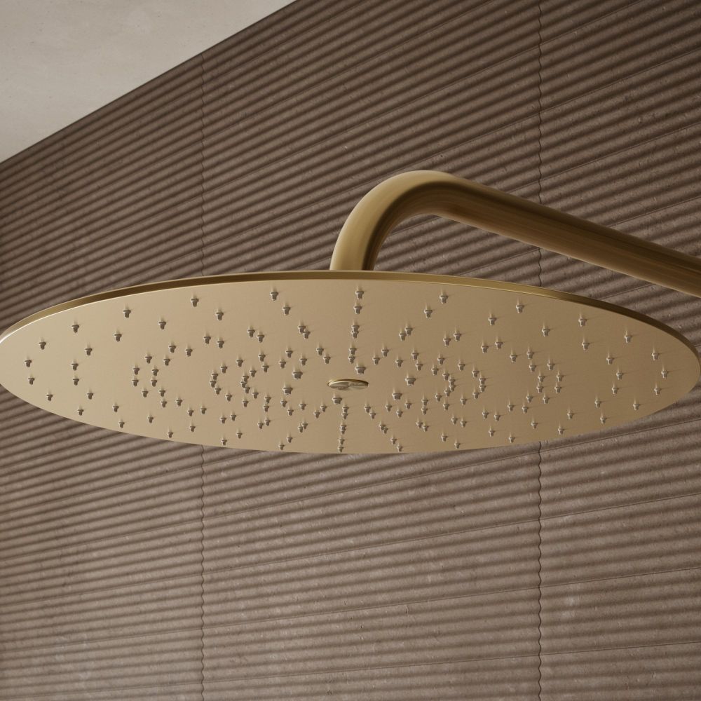 Aqualisa S3 Gold Wall Fixed Shower Head detailed view upon a brown tiled background