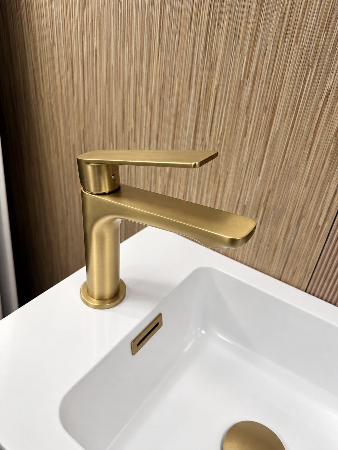 Brushed brass bathroom tap displayed with a white basin at Easy Bathrooms St Albans.