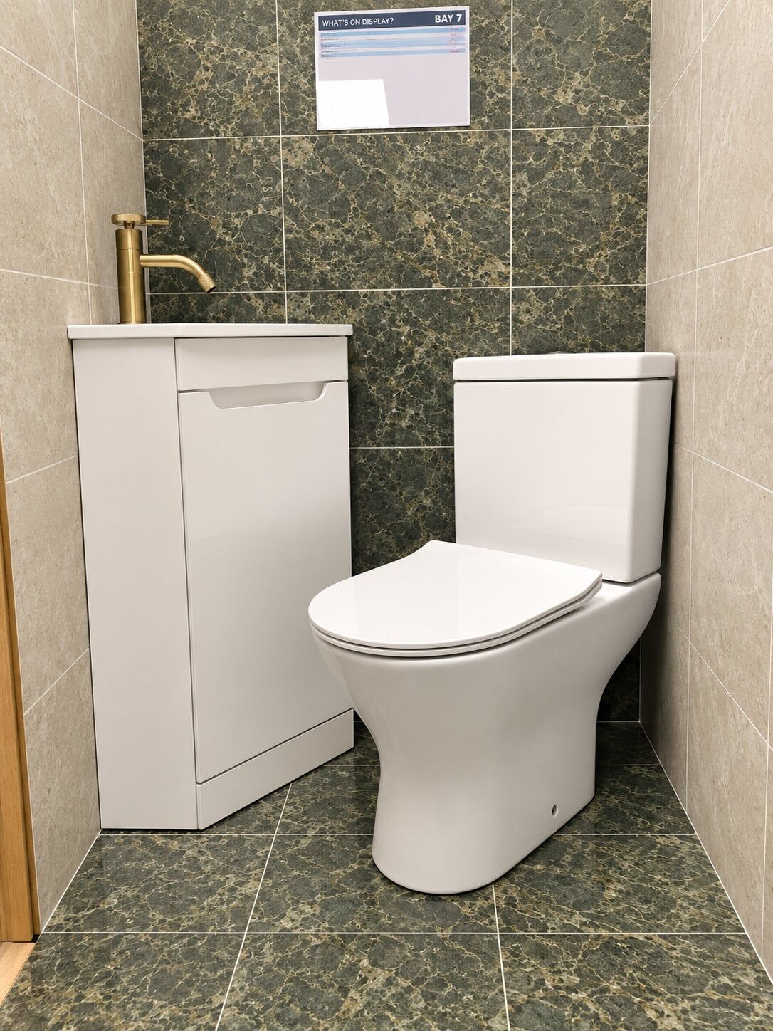 bathroom showroom display featuring corner vanity unit and corner toilet