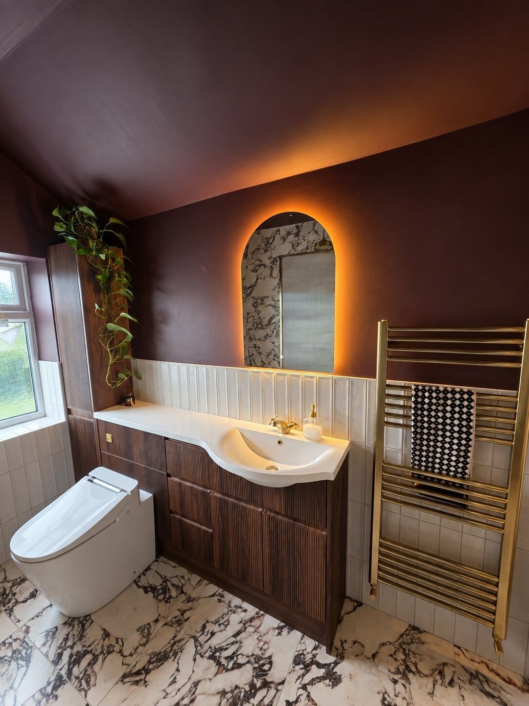 Bold marble tiles in a contemporary bathroom with purple walls and fold furniture
