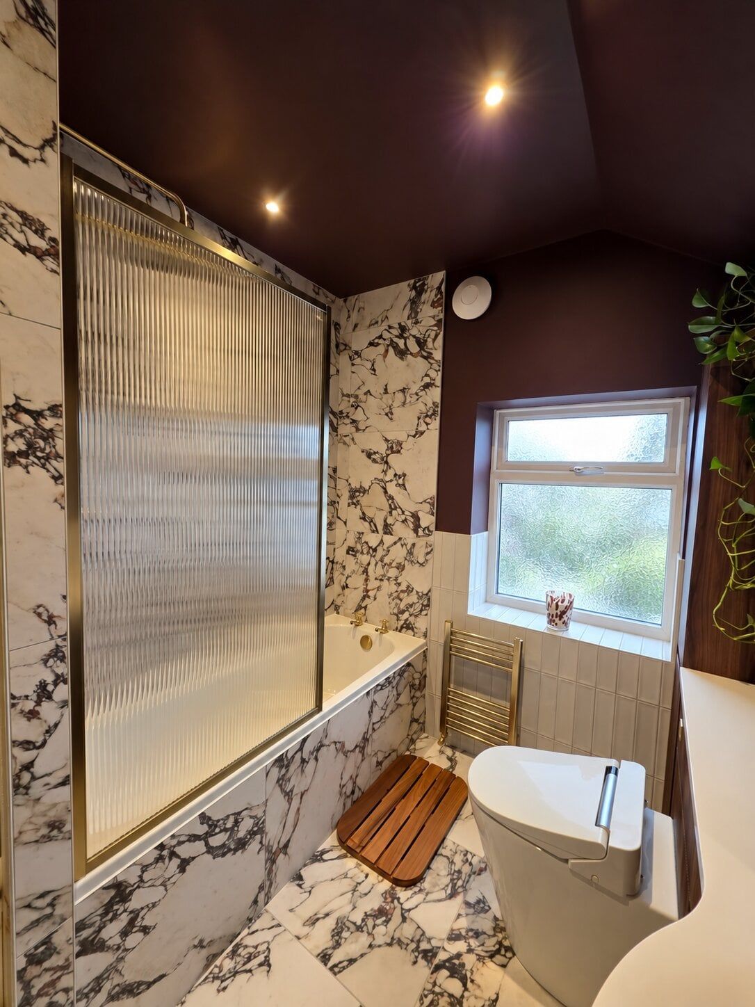Statement fluted glass shower screen in a premium bathroom by Easy Bathrooms & Tiles