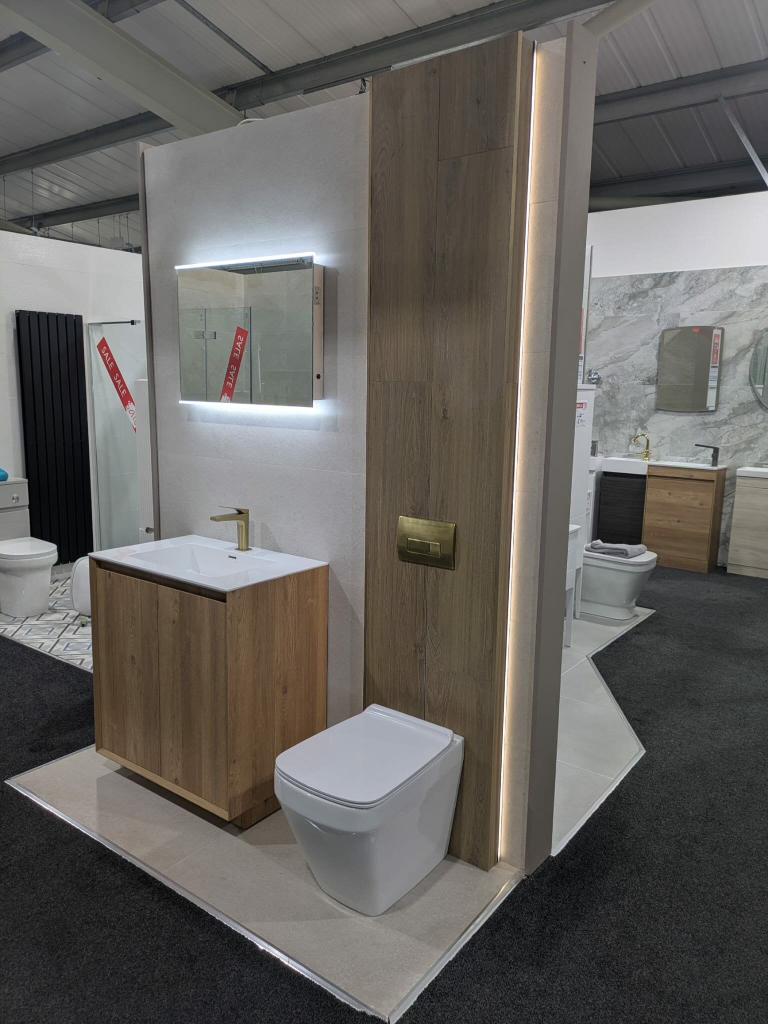New bathroom display at Easy Bathrooms Bolton featuring wood-effect furniture, white sanitaryware and neutral tiles.
