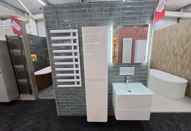 Bathroom display featuring designer heated towel rail, gloss bathroom cabinets and LED mirror