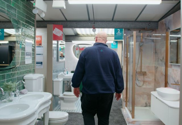 Sales assistant walking through bathroom furniture displays at Easy Bathrooms Newcastle Airport
