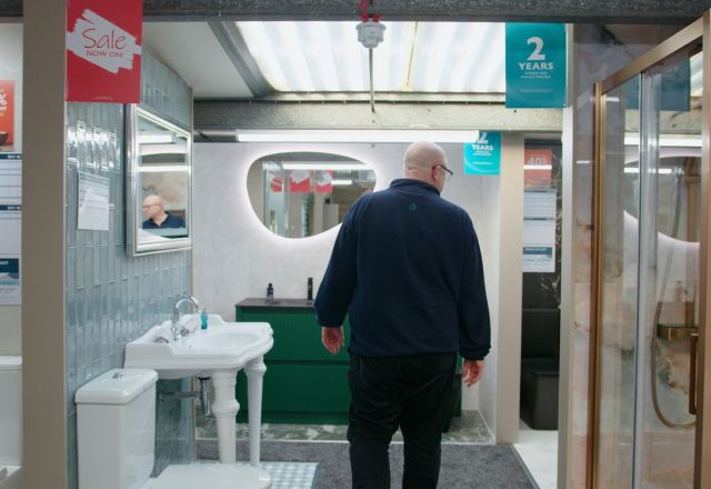 Sales assistant walking through bathroom furniture displays at Easy Bathrooms Newcastle Airport