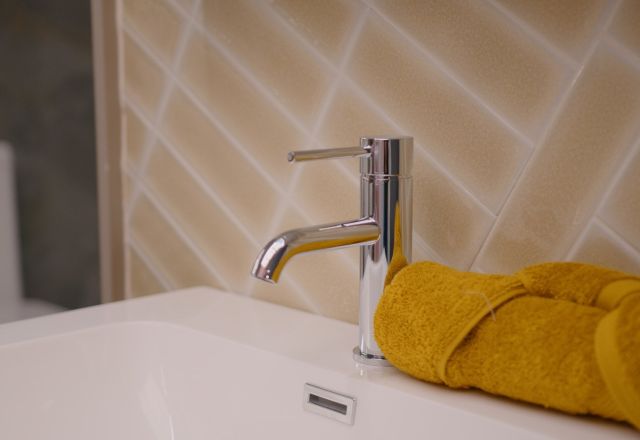 Showroom display of bathroom furniture and tiles in warm yellow tones