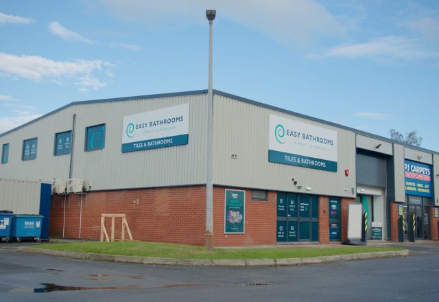 Easy Bathrooms & Tiles Newcastle Airport building from the outside showing parking
