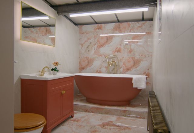 Showroom bathroom furniture display with pink marble tiles and terracotta bath and furniture