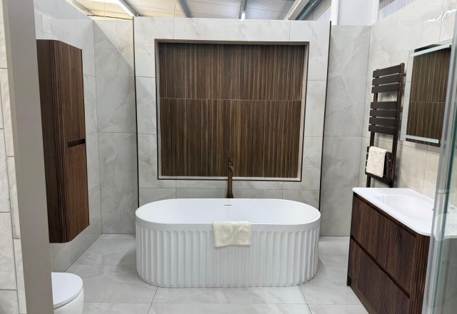 Freestanding bath and dark wood furniture in the Lewisham showroom
