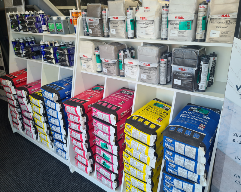 Display of Ultra tile adhesives and tiling products available at the Easy Bathrooms Edmonton showroom.