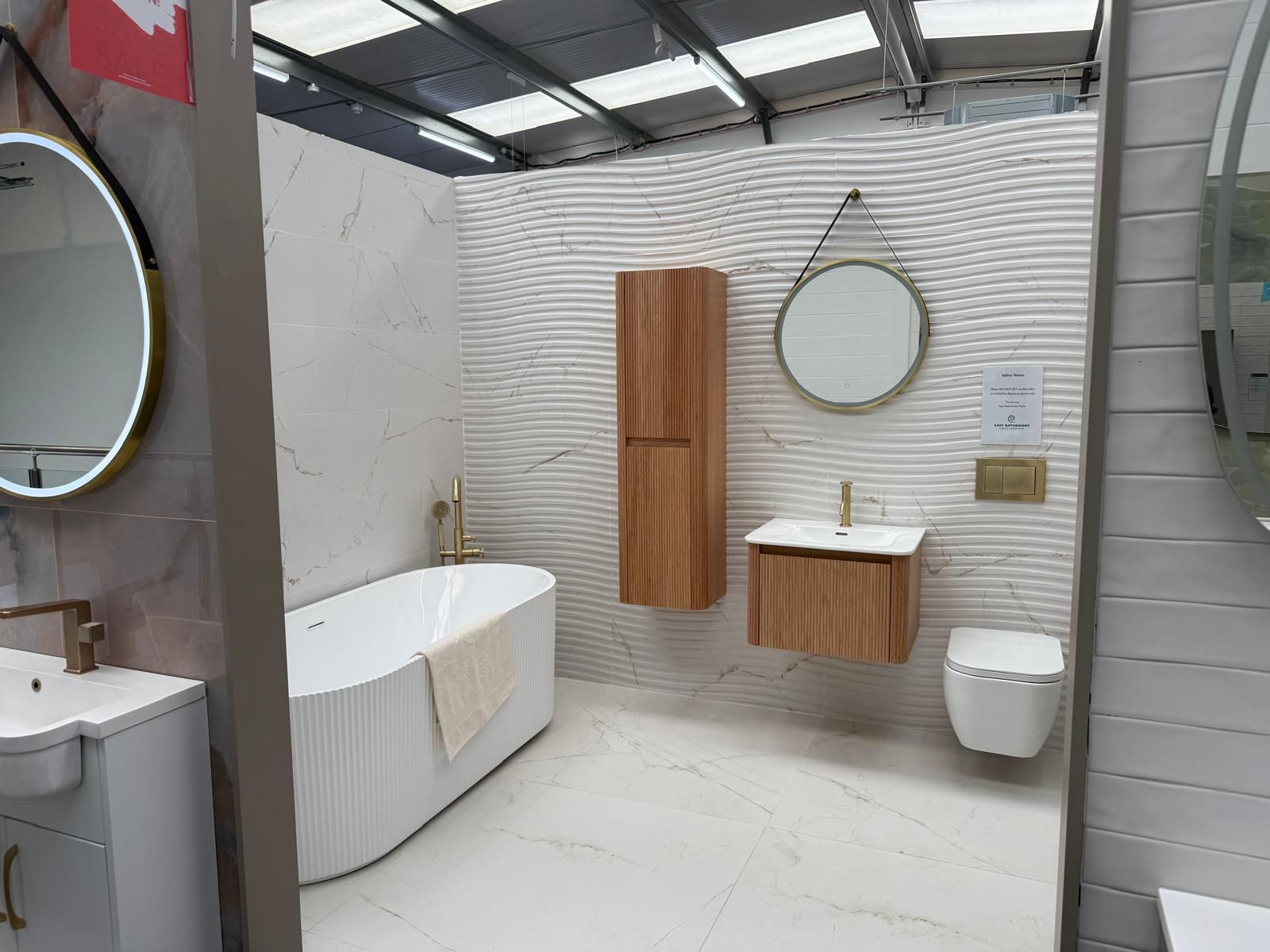Fluted bath and wood-effect furniture at Easy Bathrooms Lewisham
