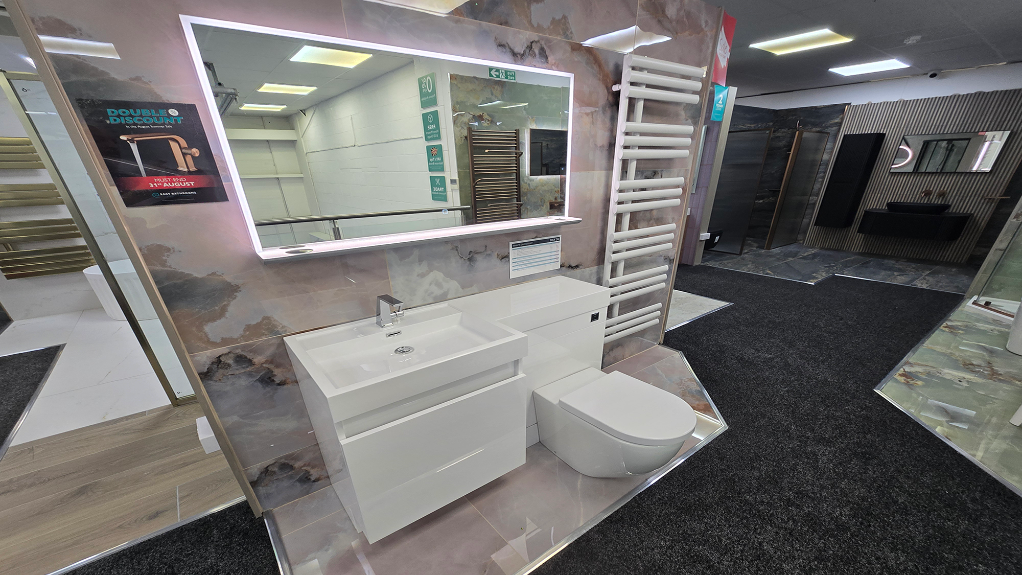 Easy Bathrooms & Tiles Showroom Newbury display stand featuring a modern bathroom suite with LED mirror and compact sink / WC