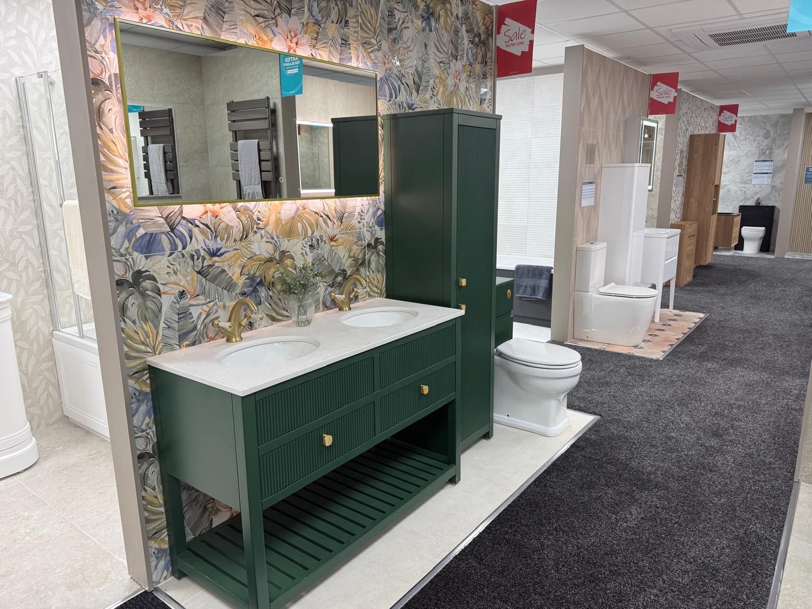 Showroom bathroom display featuring emerald green bathroom furniture, botanical tiles and LED mirror