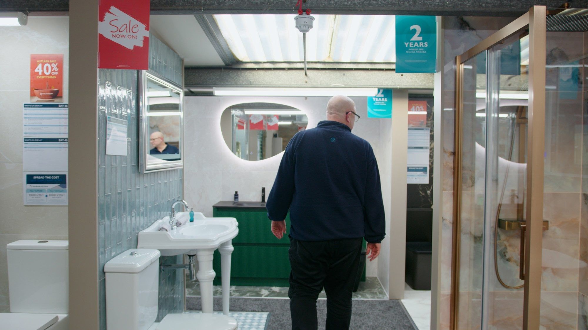 Sales assistant walking through bathroom furniture displays at Easy Bathrooms Newcastle Airport