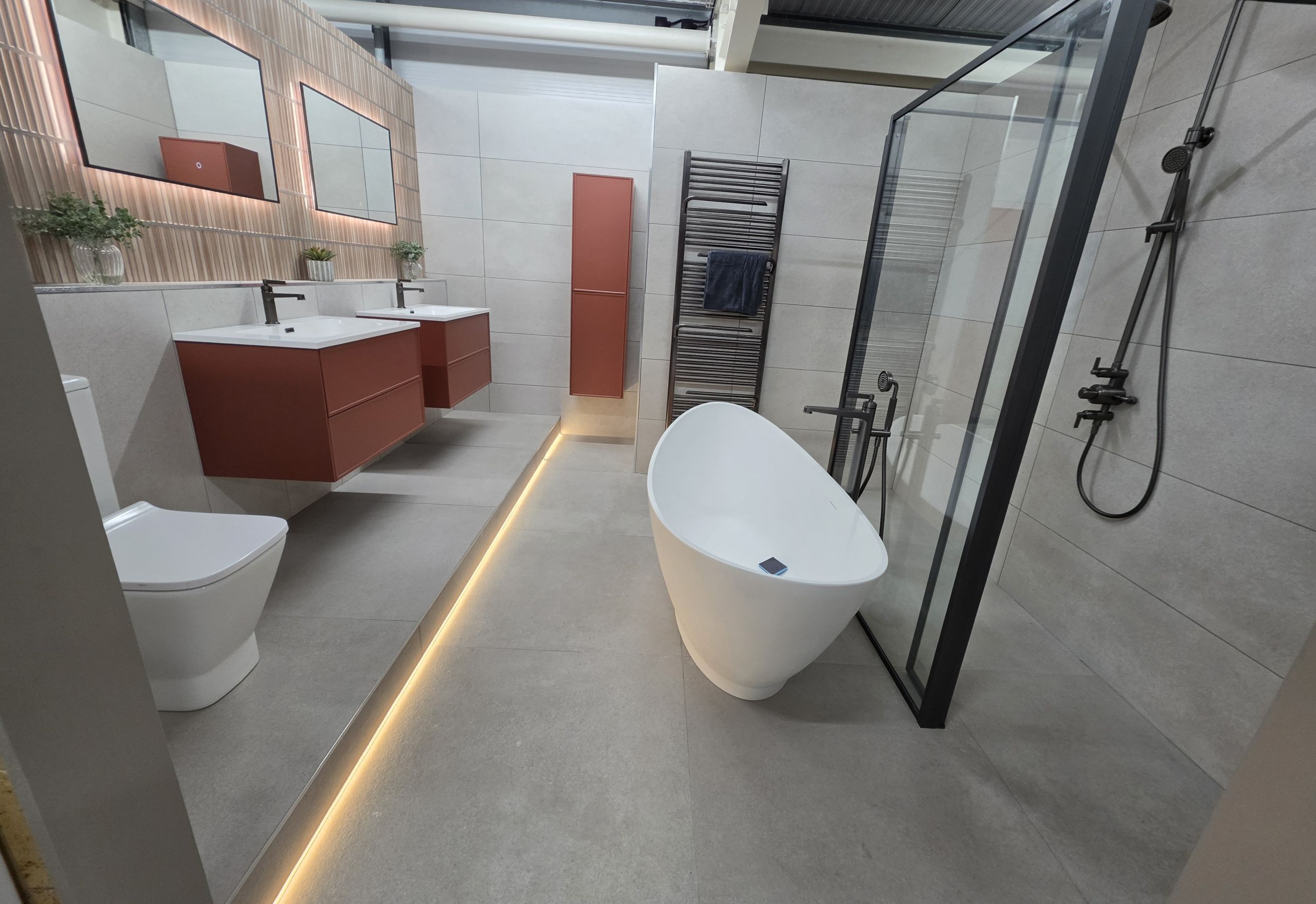 Bathroom display featuring free standing bath, double vanity vasins and modern shower tray