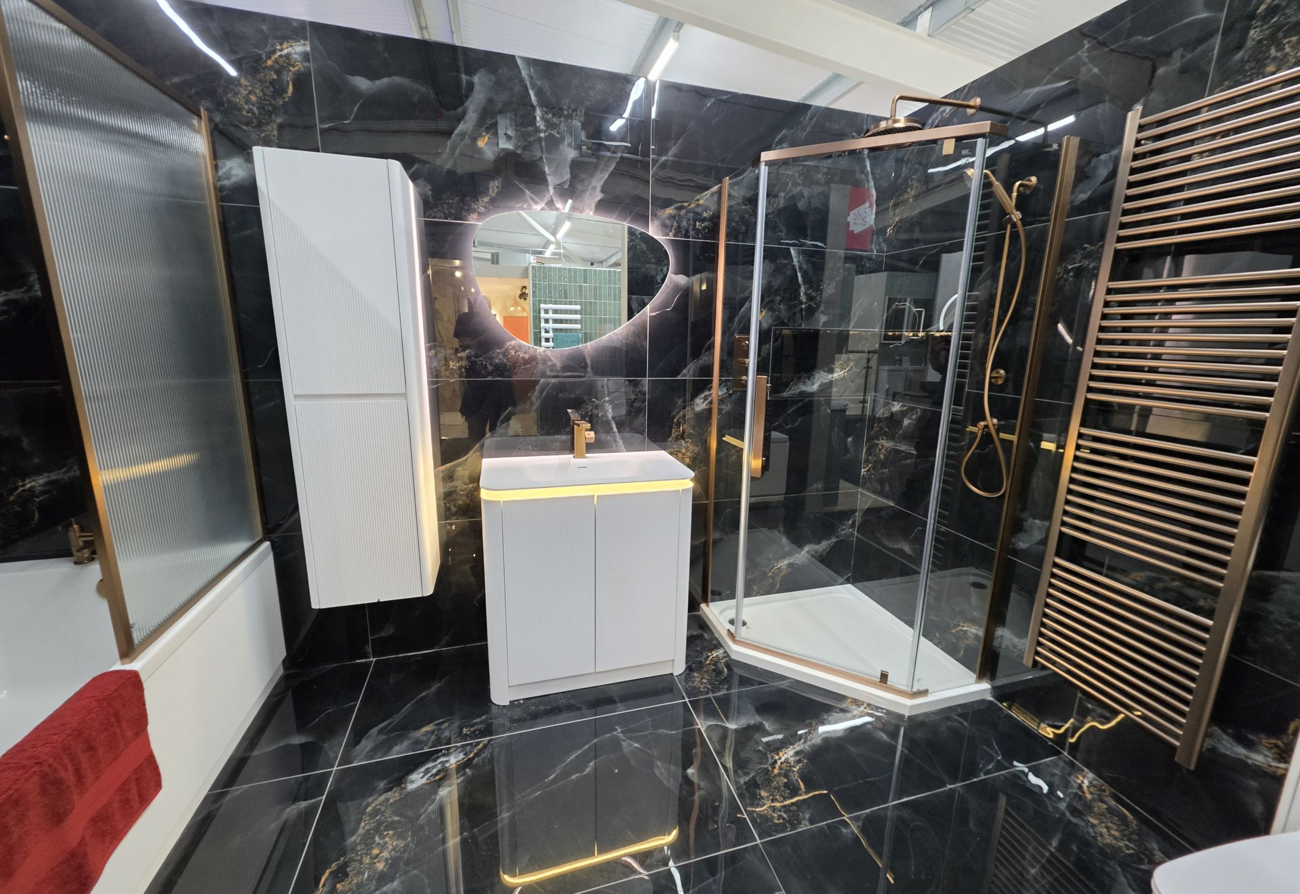 Showroom bathroom display featuring black onyx marble tiles and modern metallic bathroom furniture