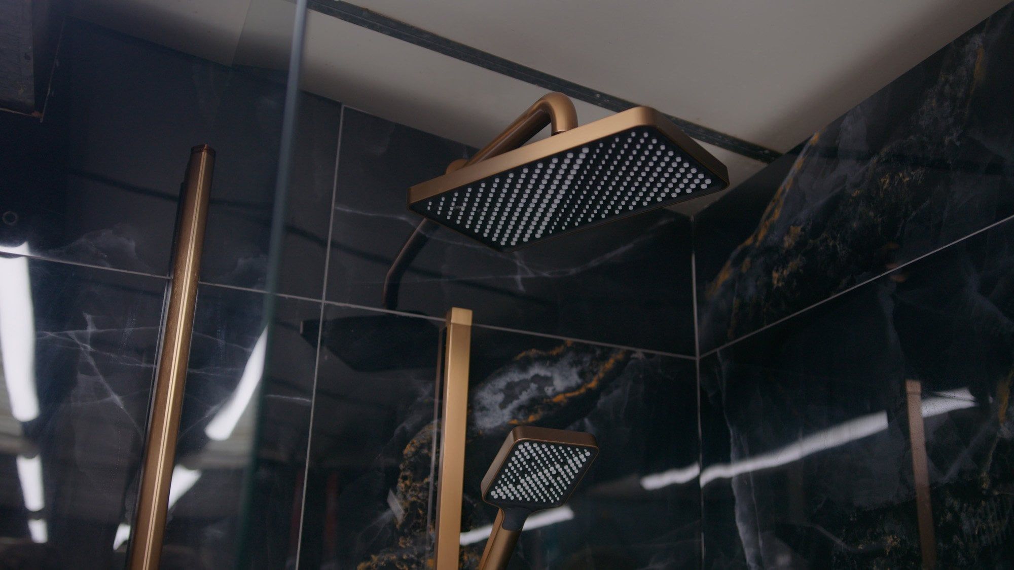 Bathroom furniture display in Easy Bathrooms showroom featuring copper shower and black tiles