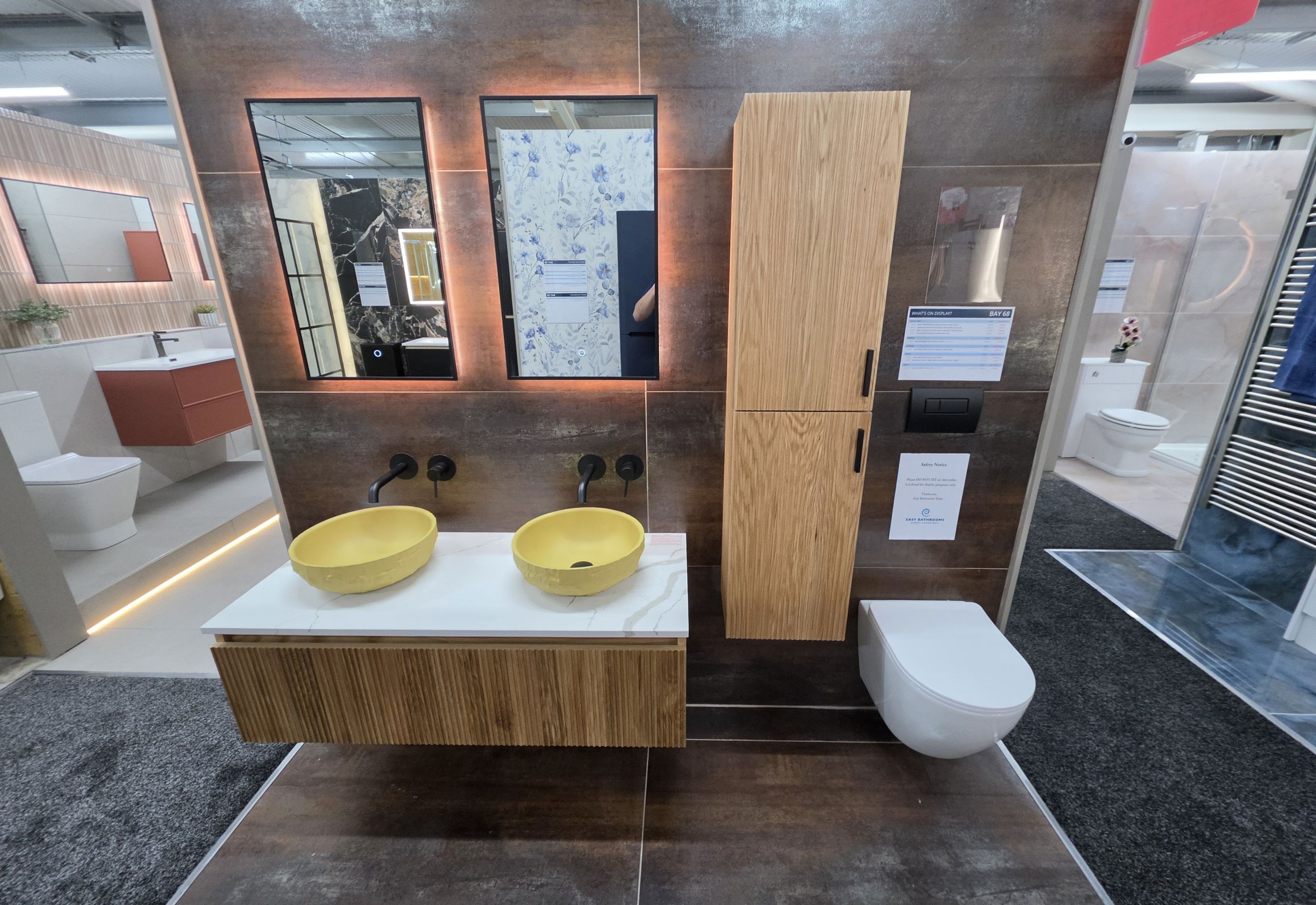 Bathroom display furniture featuring patina tiles, ribbed wood effect bathroom furniture and counter top stone sinks in yellow