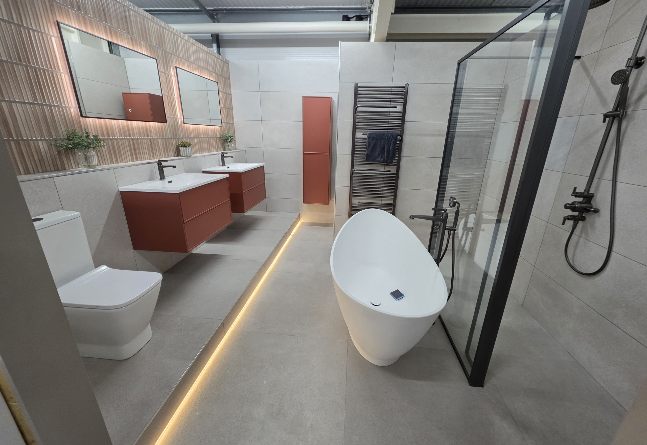 Bathroom display showing LED strip lights, LED light, floating vanity and basin, toilet, black trim shower screen