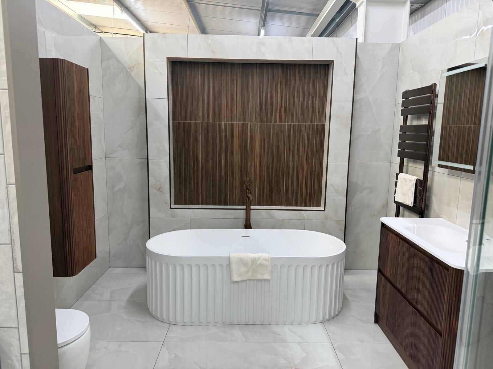 Freestanding bath and dark wood furniture in the Lewisham showroom
